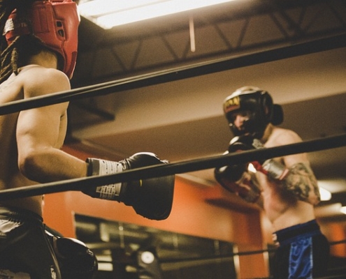 Two men sparring in Krav Maga, demonstrating striking and grappling techniques.